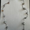 Langere ketting met bruine schelpkralen, parels en zilverkleurige buisjes