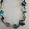 Ketting met 3 kleuren schelpkralen met zilverkleurige kubus