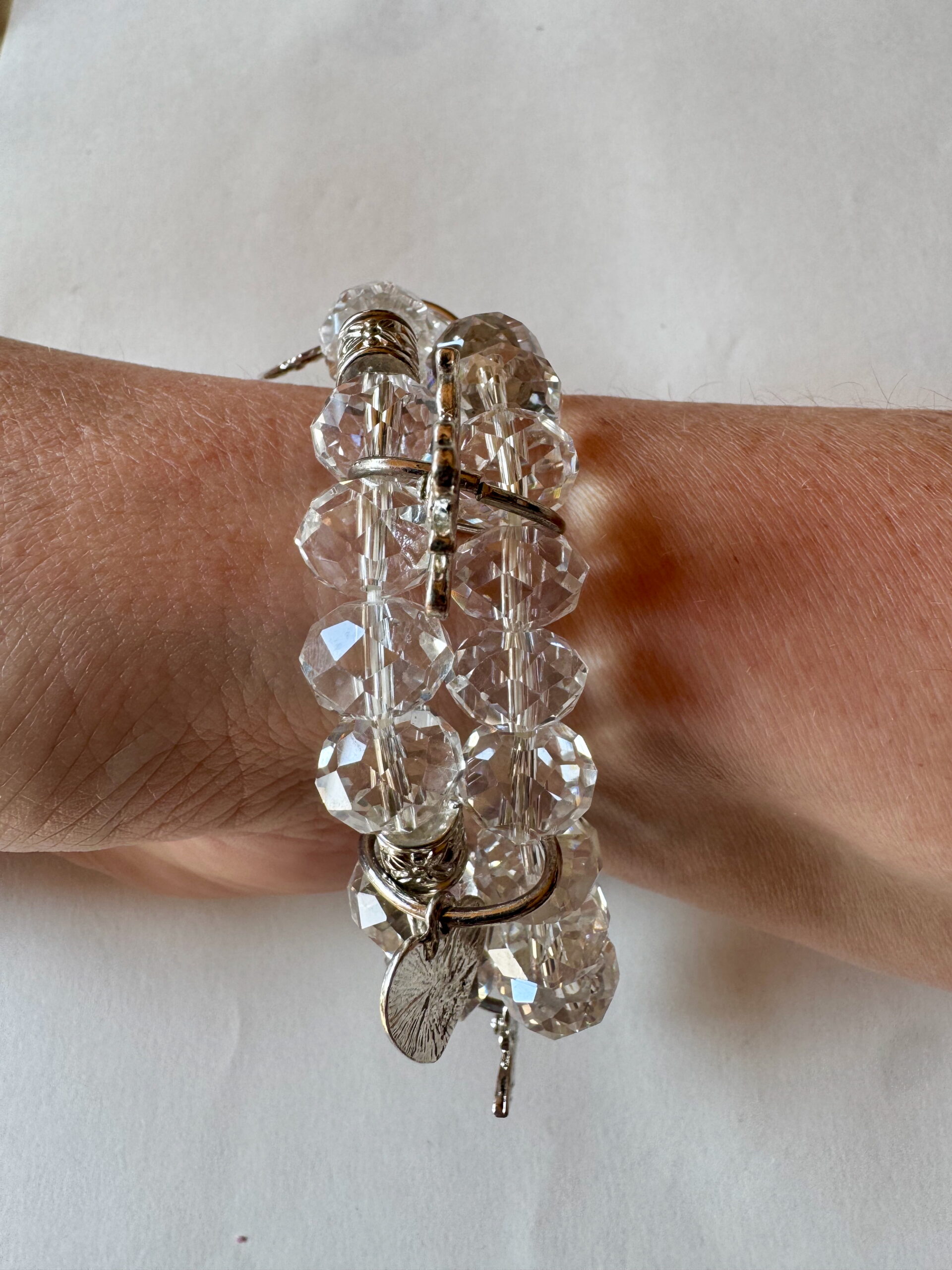 Armband op elastiek met transparante facetkralen met bedels