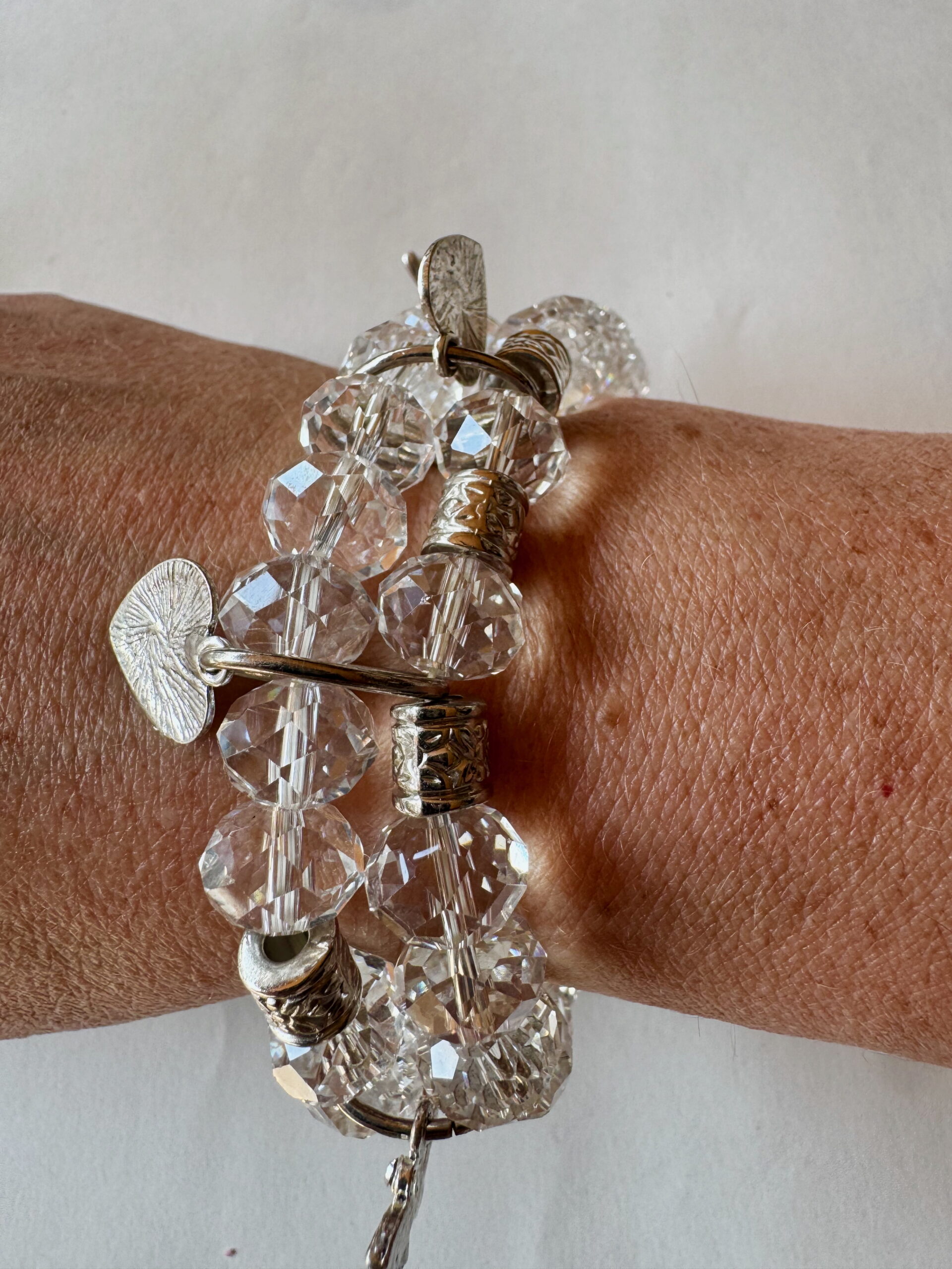 Armband op elastiek met transparante facetkralen met bedels