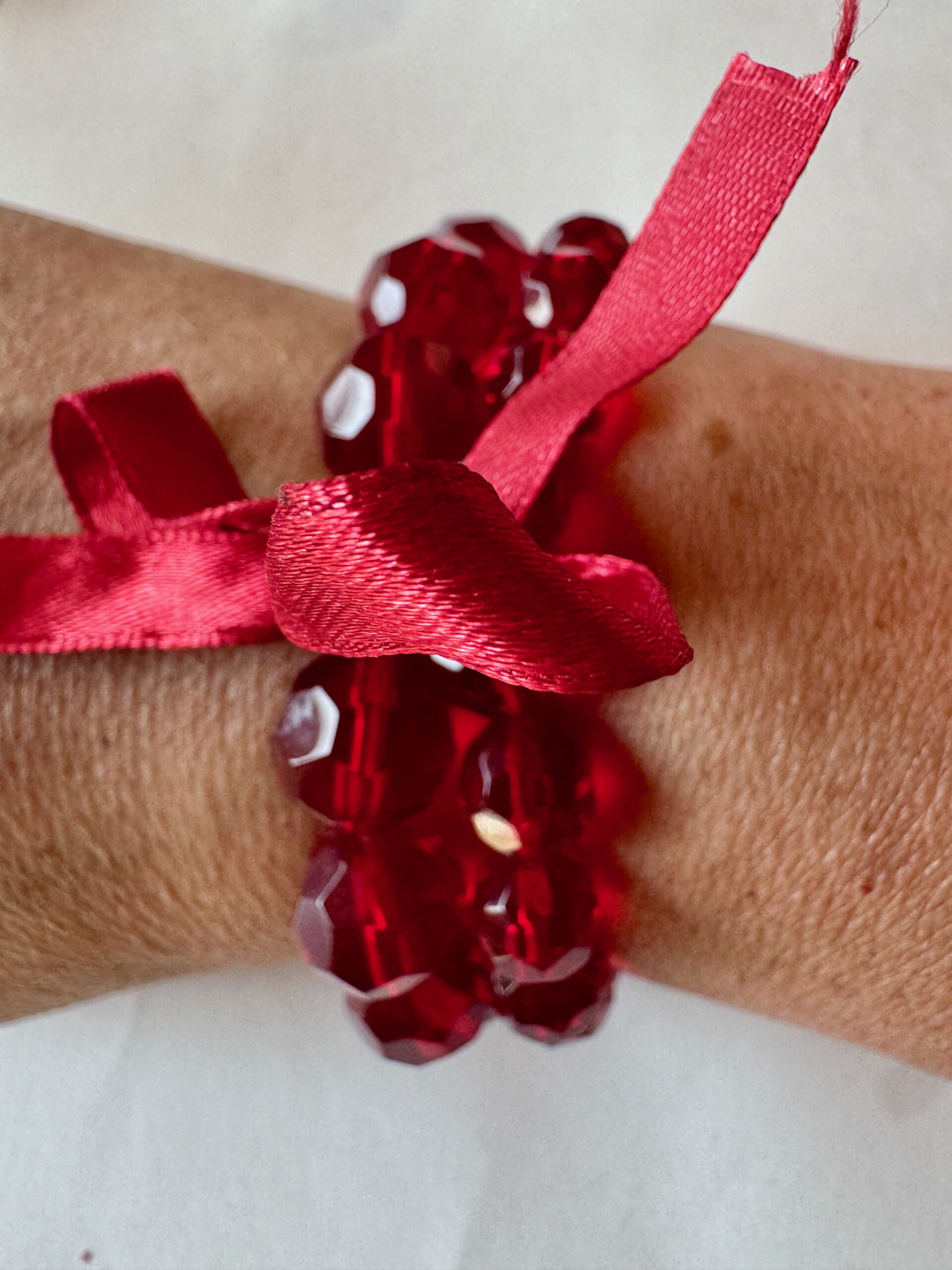 Armband op elastiek met rode facetkralen