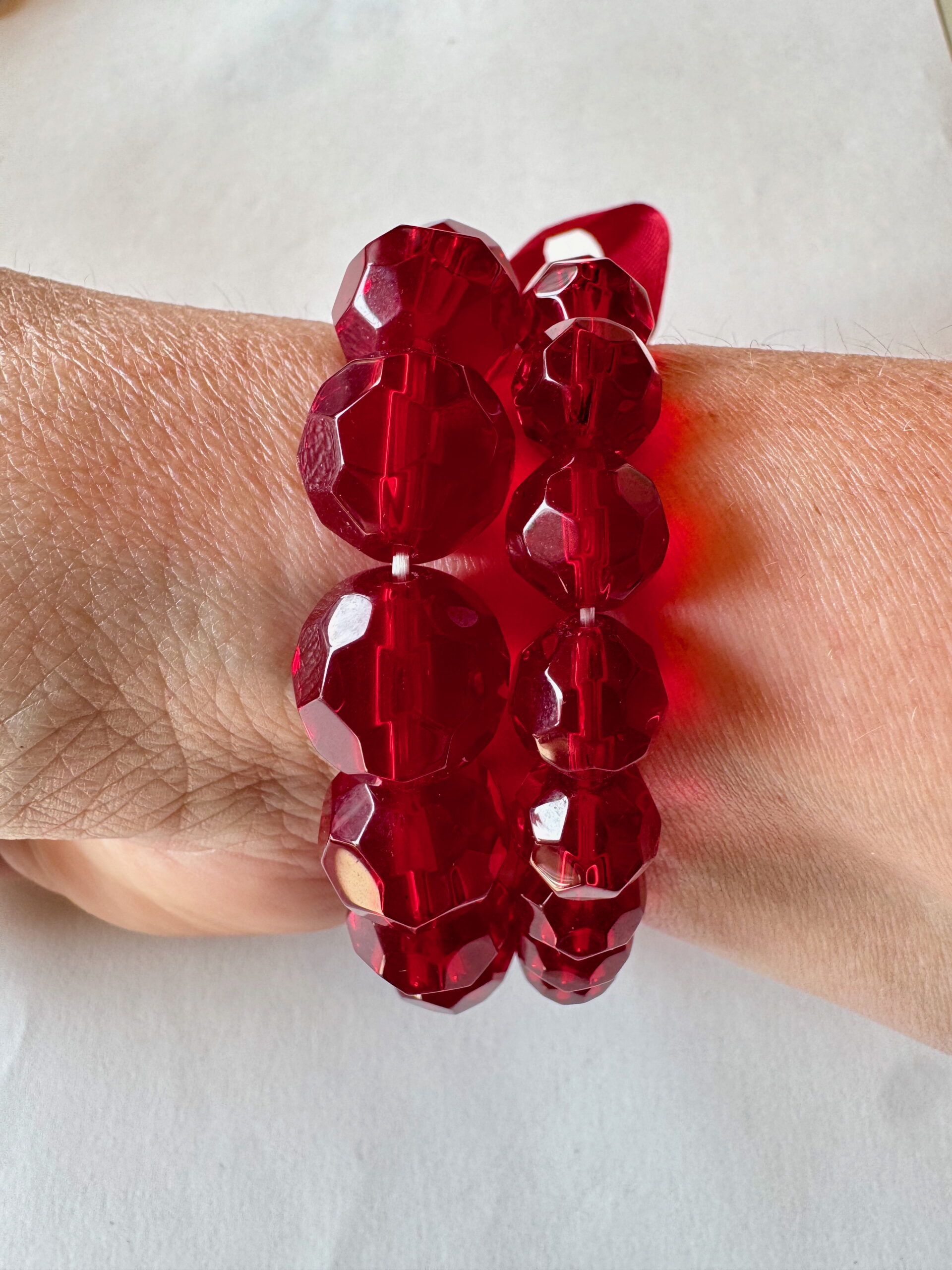 Armband op elastiek met rode facetkralen