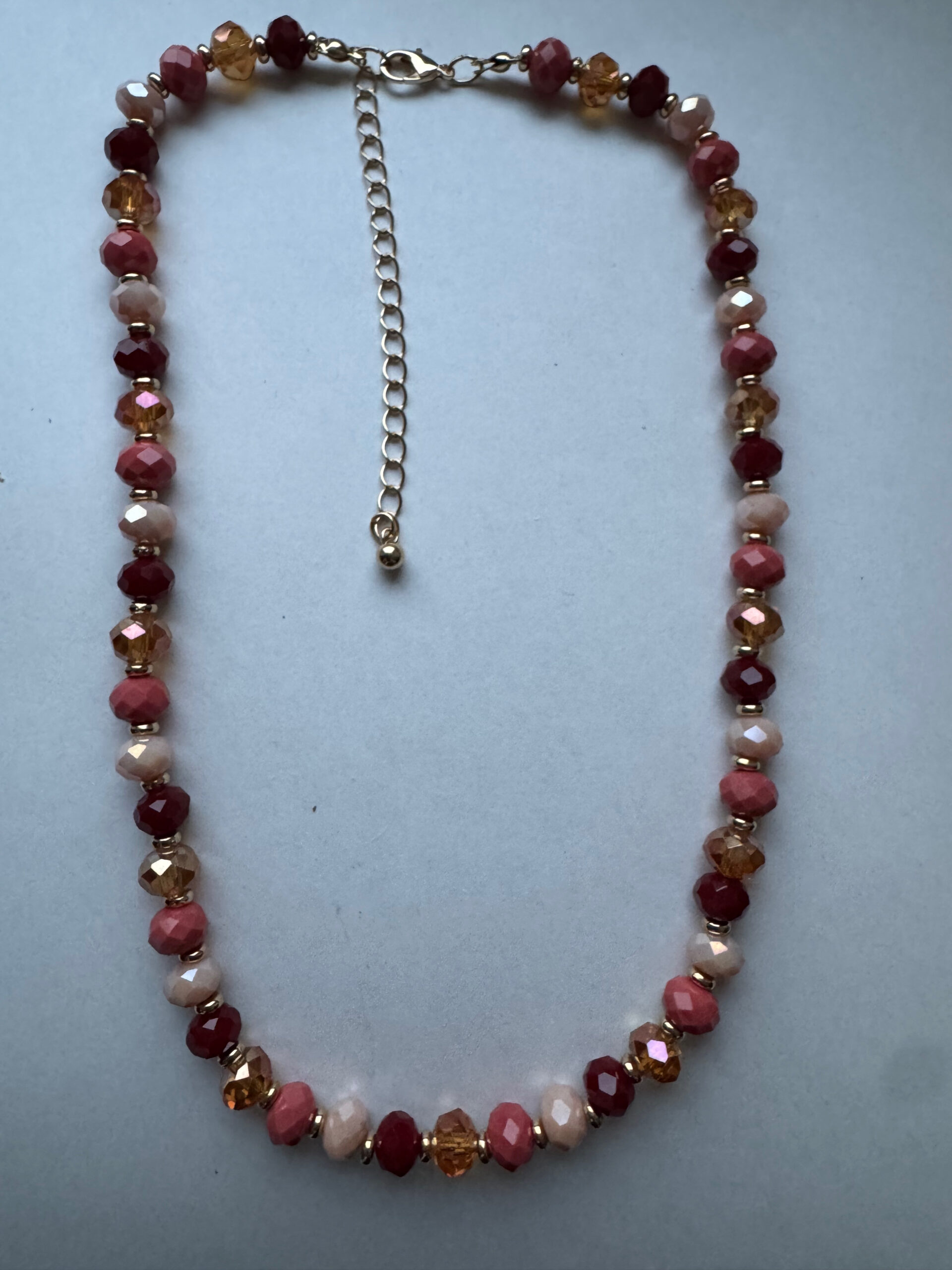 Ketting goudkleurig met mooie facetkraaltjes in rood/oranje tinten