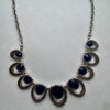 Mooie zilverkleurige ketting met blauwe hangers in verdeler