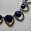 Mooie zilverkleurige ketting met blauwe hangers in verdeler