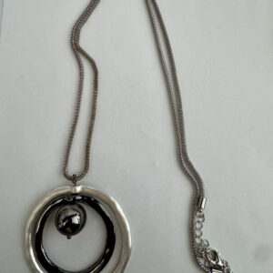 Lange ketting 3 kleuren rondjes een een grote zwarte kraal in het midden