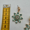 Mooie goudkleurige oorbellen met turquoise bloem